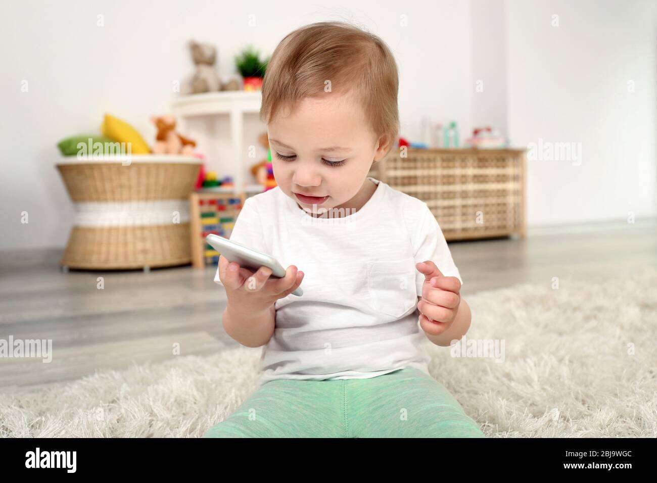 Baby Using Play Phone Cute baby girl playing with a smartphone Stock Photo - Alamy