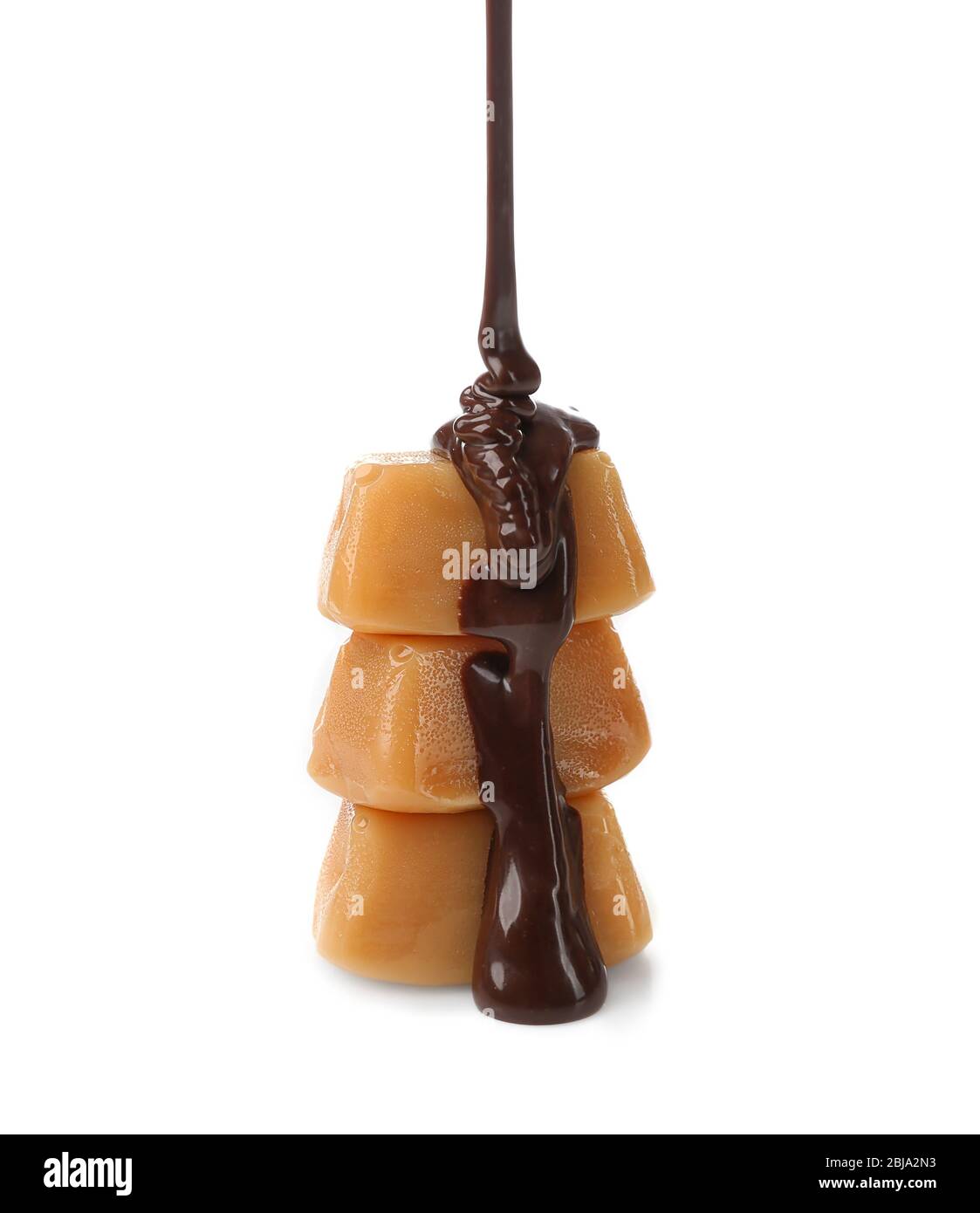 Melted chocolate with caramel candies, isolated on white Stock Photo