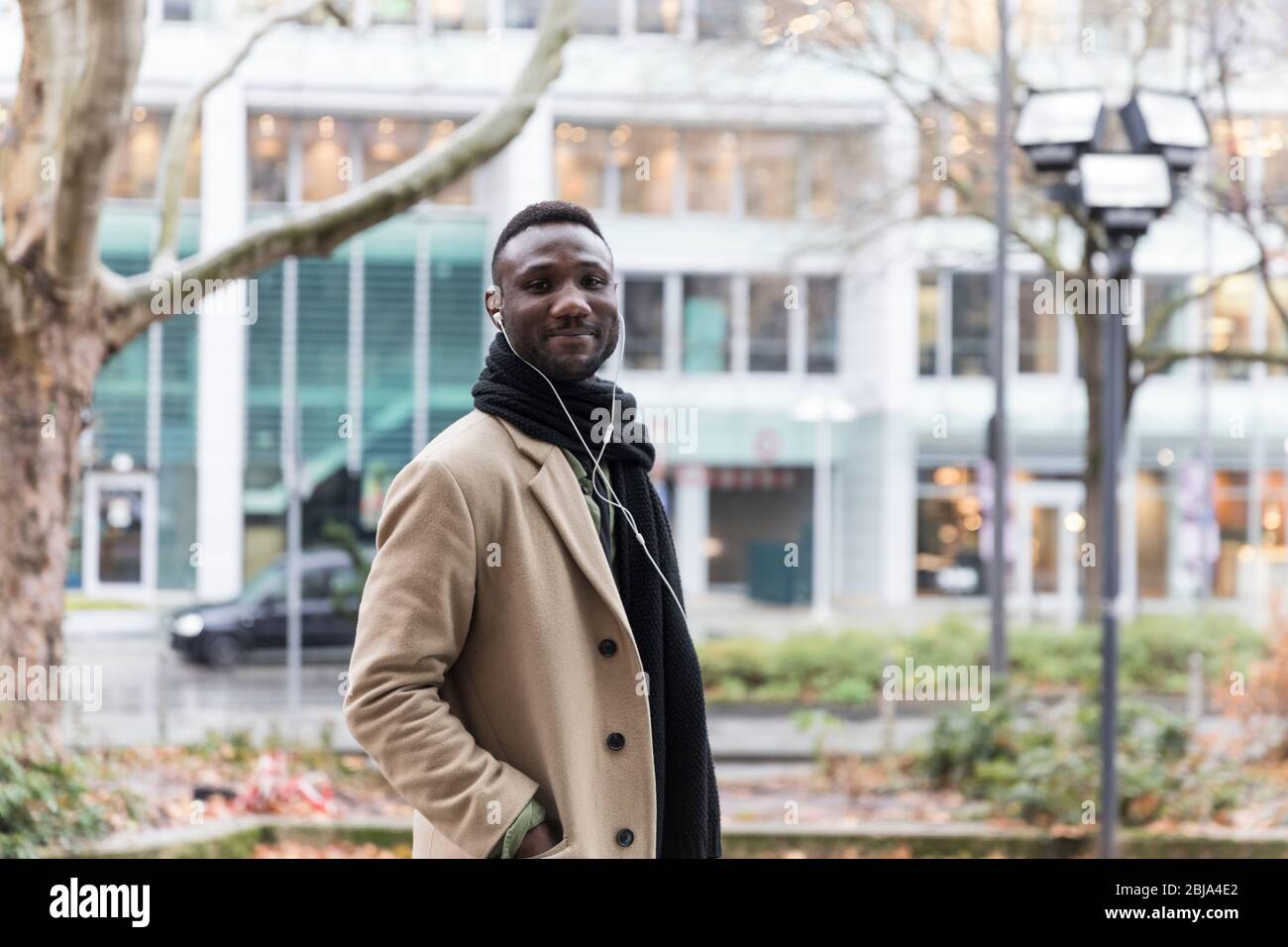 Fashionable Black Man Wearing Beige Coat Turning Towards Camera Stock Photo  - Alamy