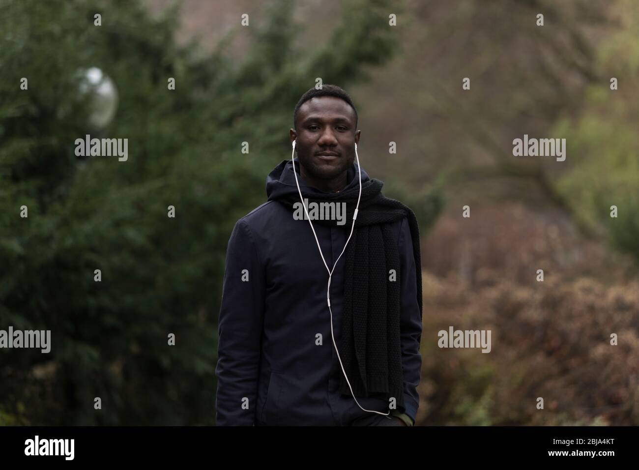 Medium Shot Portrait of Young Black Man in Park Stock Photo - Alamy