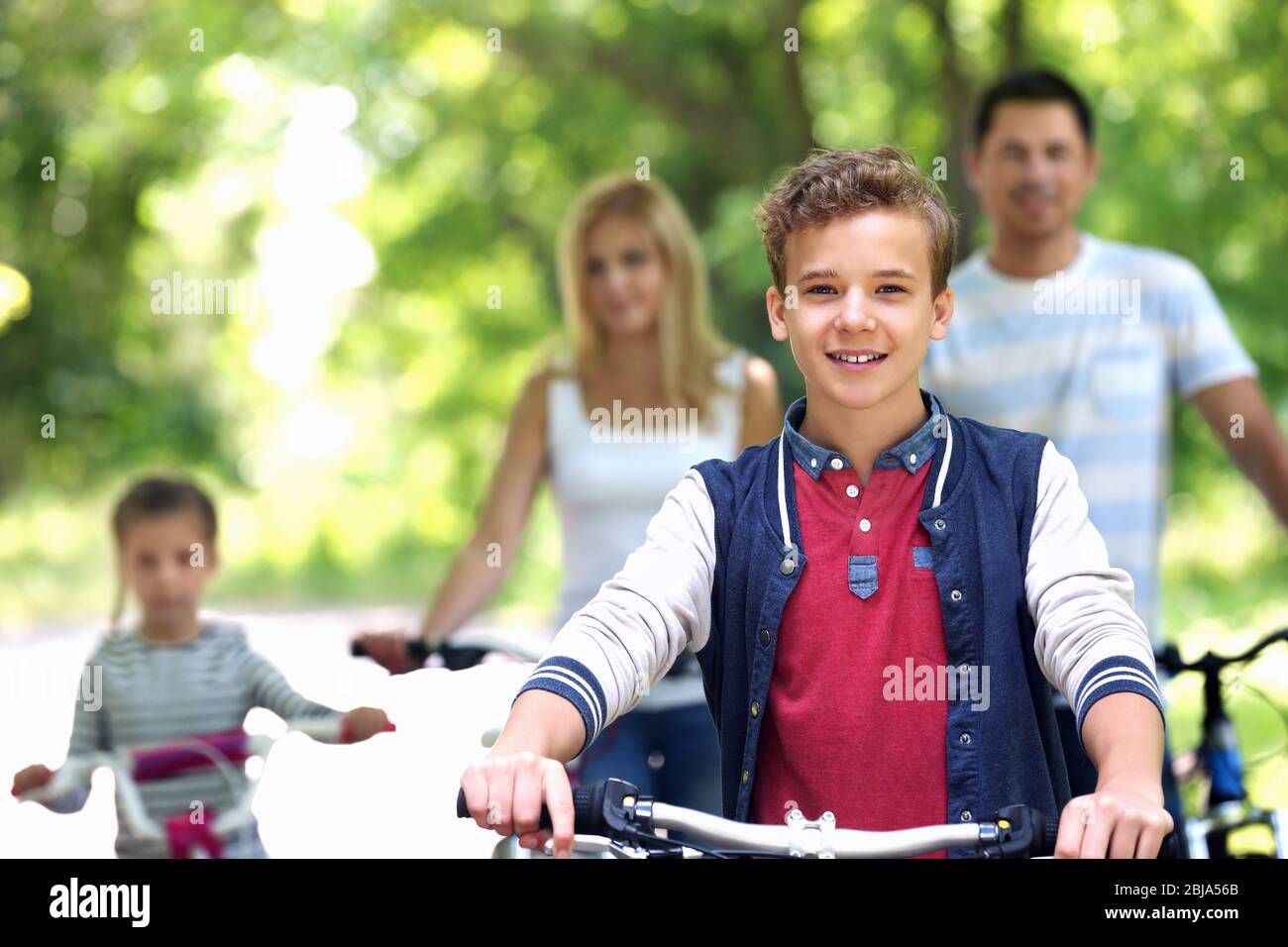 Cute boy with family on bike ride in park Stock Photo Alamy