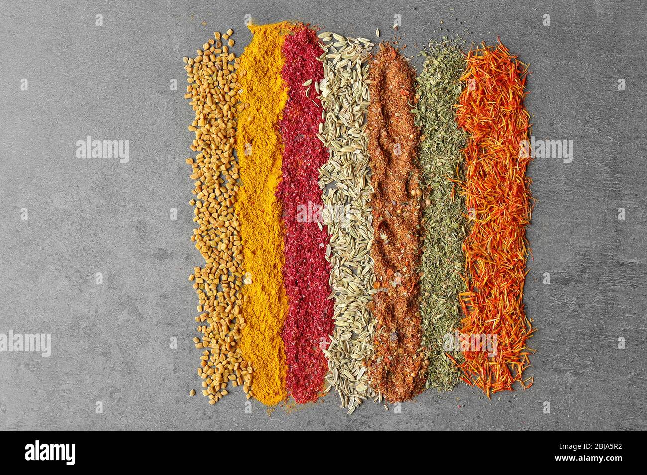Different spices on gray background Stock Photo