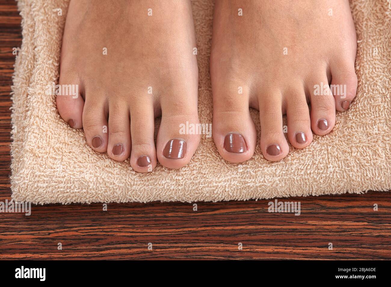 Female feet with brown pedicure on towel, closeup Stock Photo