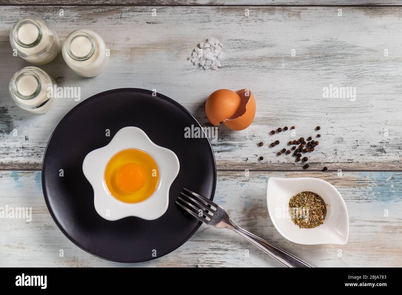 Raw egg on a rustic table top with kitchen utensils Stock Photo - Alamy
