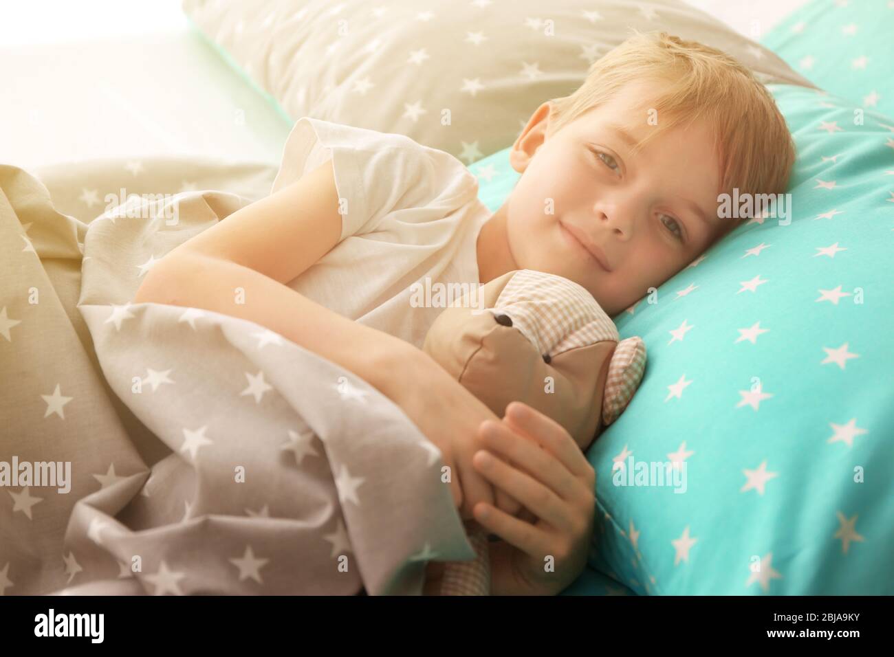 Adorable little boy hugging teddy bear in bed Stock Photo - Alamy