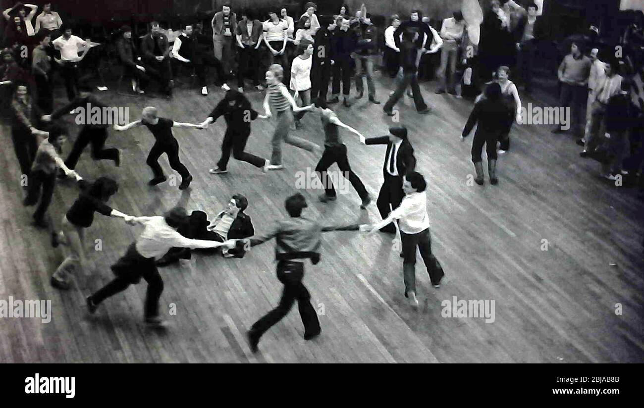 Men dance holding hands in a circle at a fundraising dance event at the Camden Centre, London, England, United Kingdom, to raise money for the 1979 Gay Pride week events. London Gay Pride that year had the theme: 'Stonewall 69 Gay Pride 79'. Stock Photo
