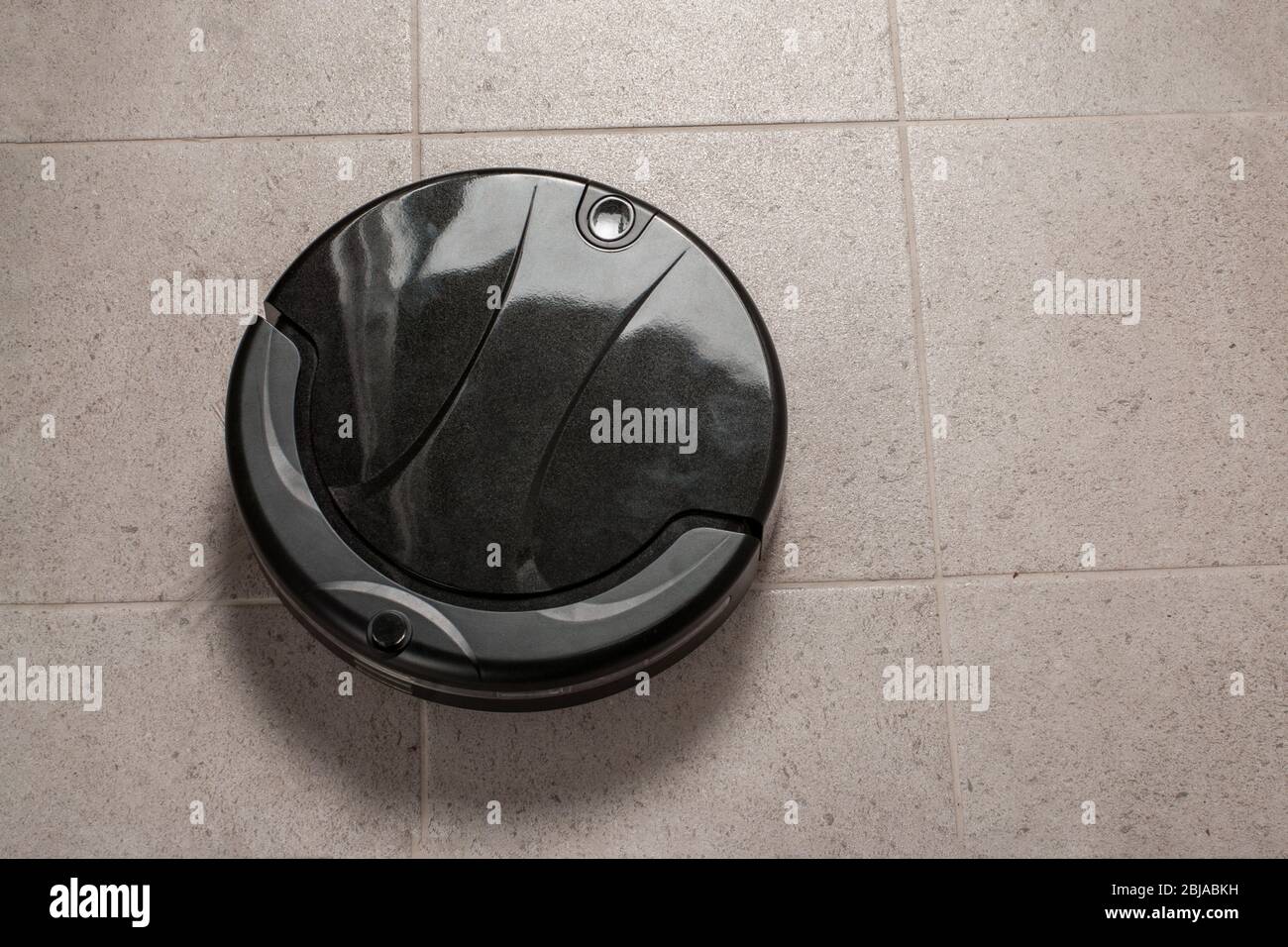Robot vacuum cleaner cleaning dust on tile floors. Modern smart