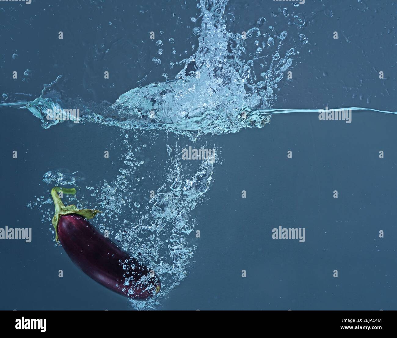 Fresh eggplant falling in water on dark background Stock Photo Alamy