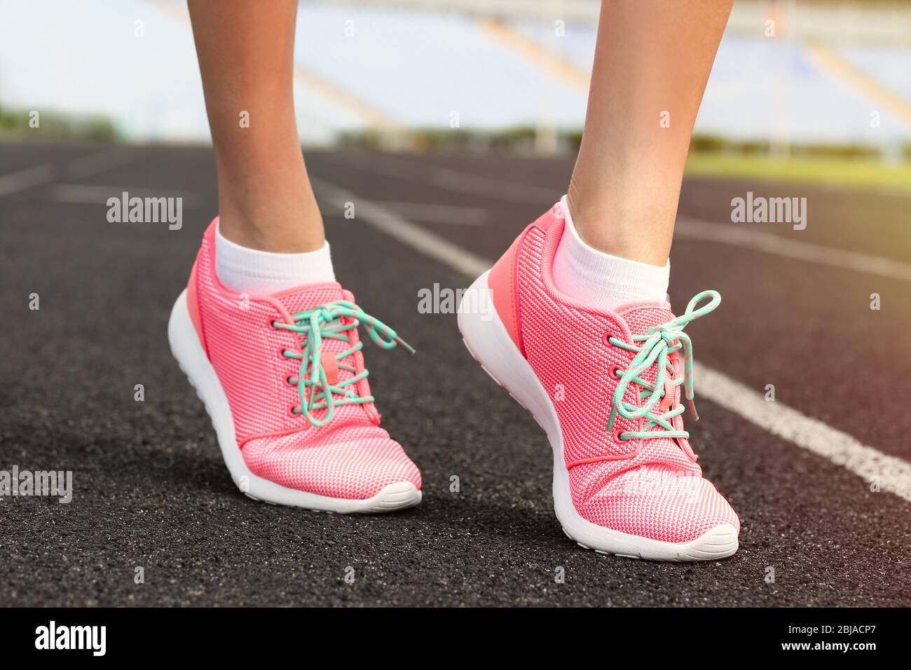 Woman wearing pink sneakers on a running stadium Stock Photo - Alamy