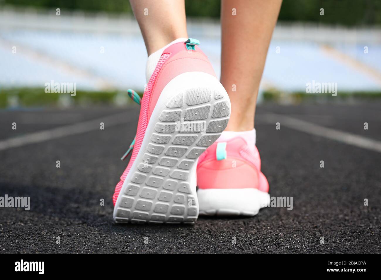 Woman wearing pink sneakers on a running stadium Stock Photo - Alamy