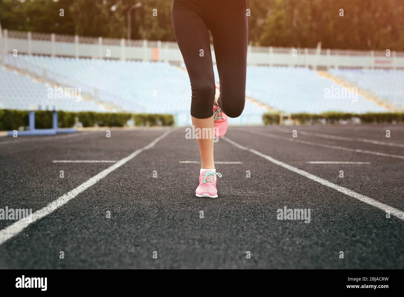 Woman running in pink sneakers on a stadium Stock Photo - Alamy