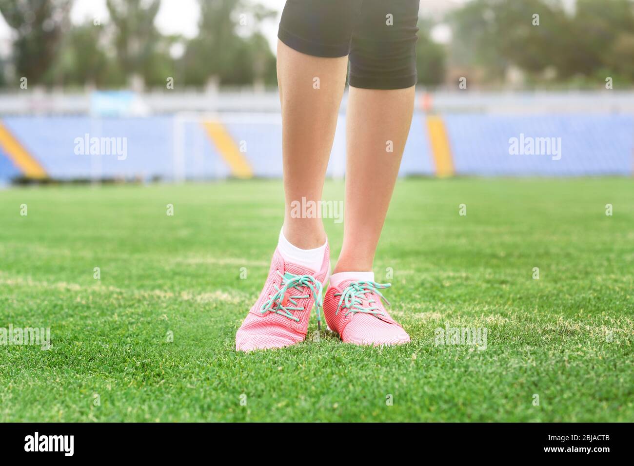Woman wearing pink sneakers and standing on a grass Stock Photo - Alamy