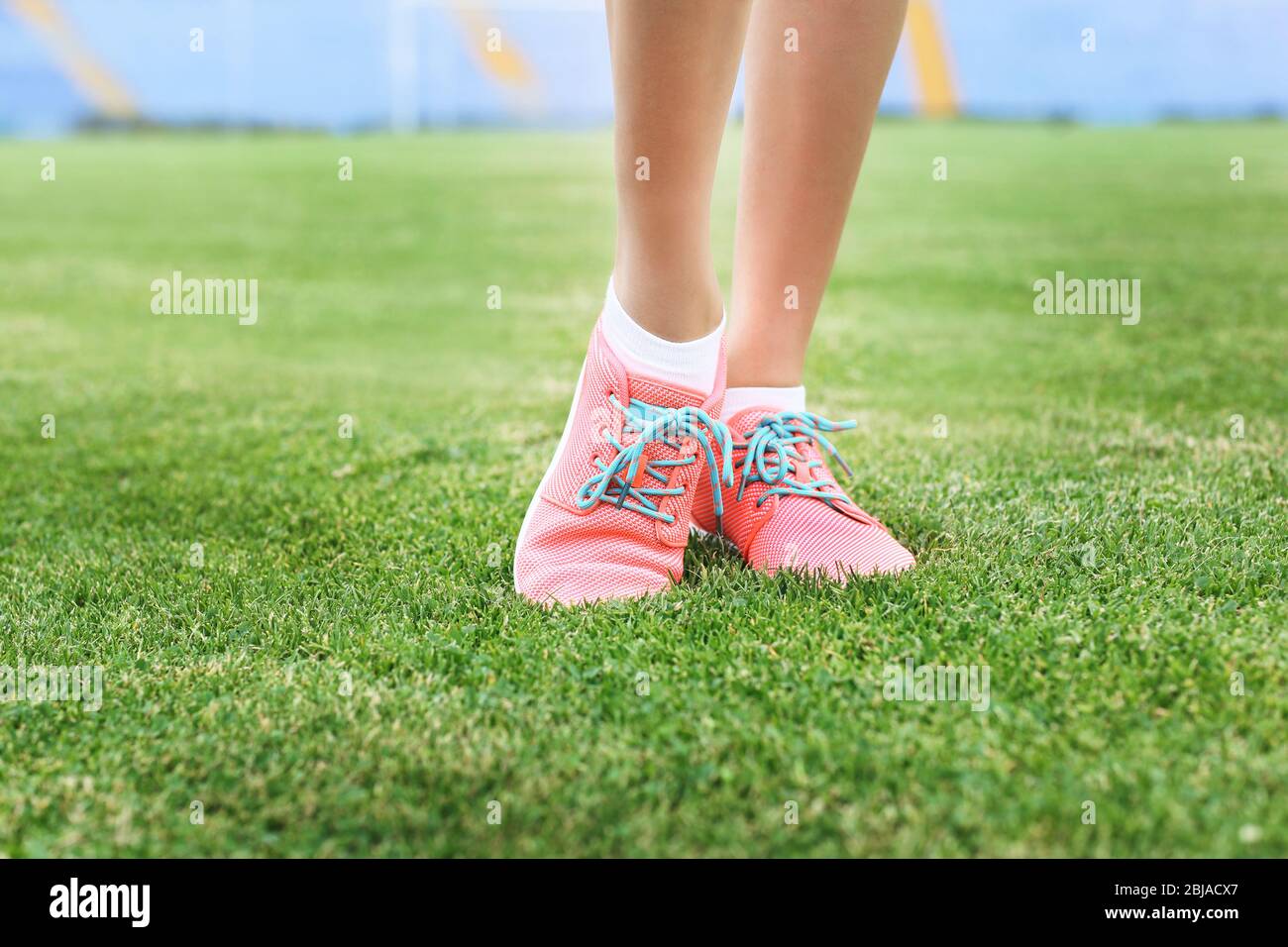 Woman wearing pink sneakers and standing on a grass Stock Photo - Alamy