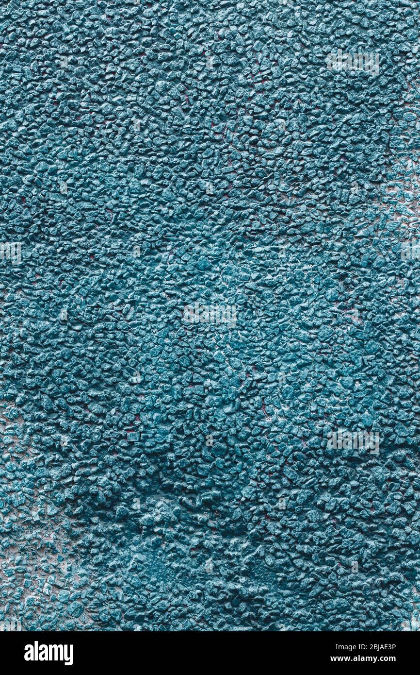 Background texture wall of a house covered with small pebbles fastened with mortar. Painted in blue. Vertical. Stock Photo