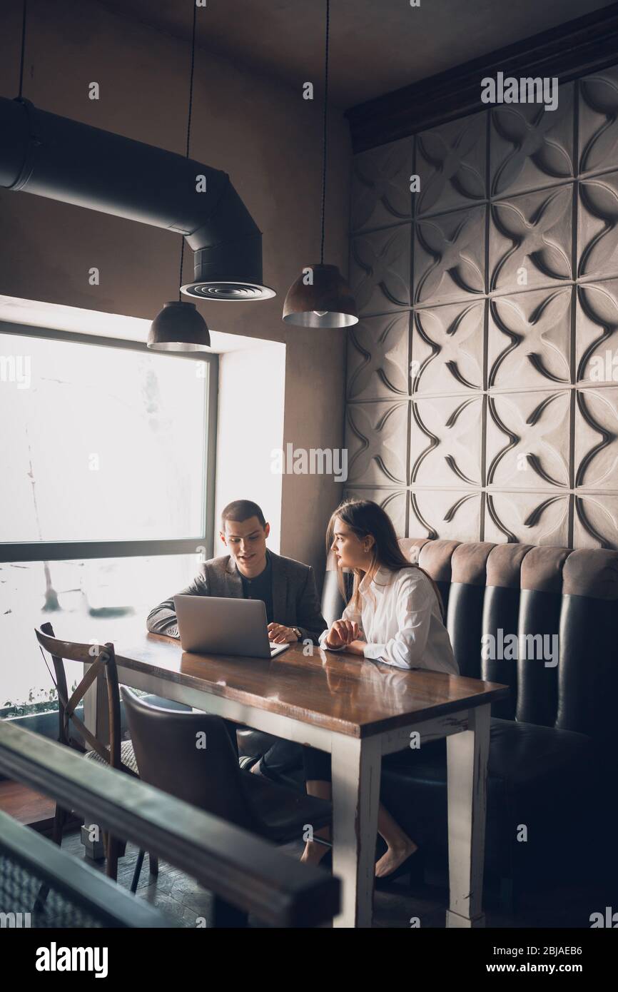 Cheerful man and woman talking, discussing at the coffee shop, cafe ...