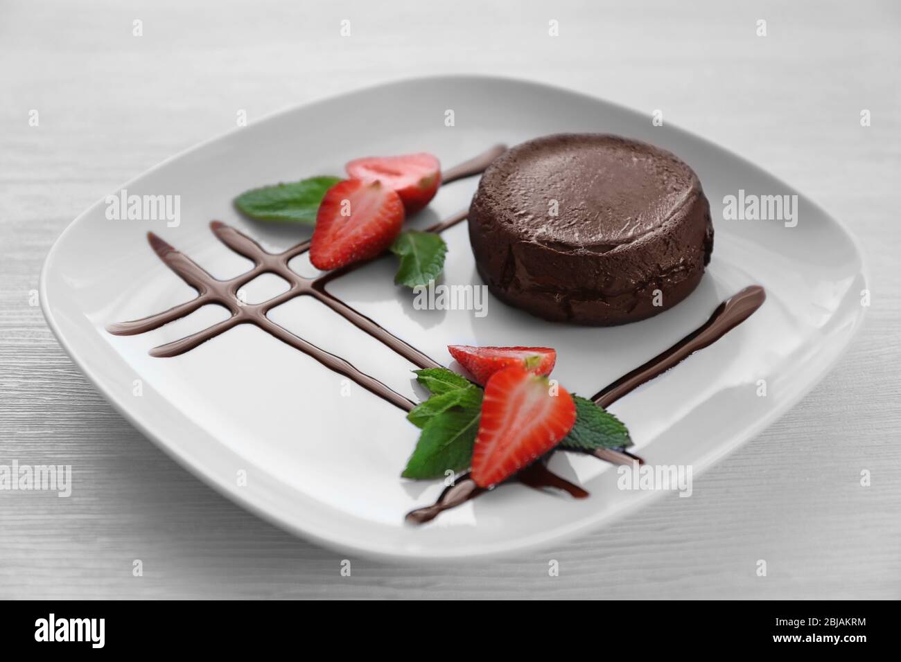 Chocolate fondant with strawberry on plate, closeup Stock Photo - Alamy