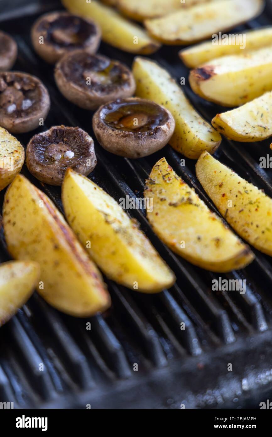 Electric grill with spicy potatoes and mushrooms Stock Photo Alamy