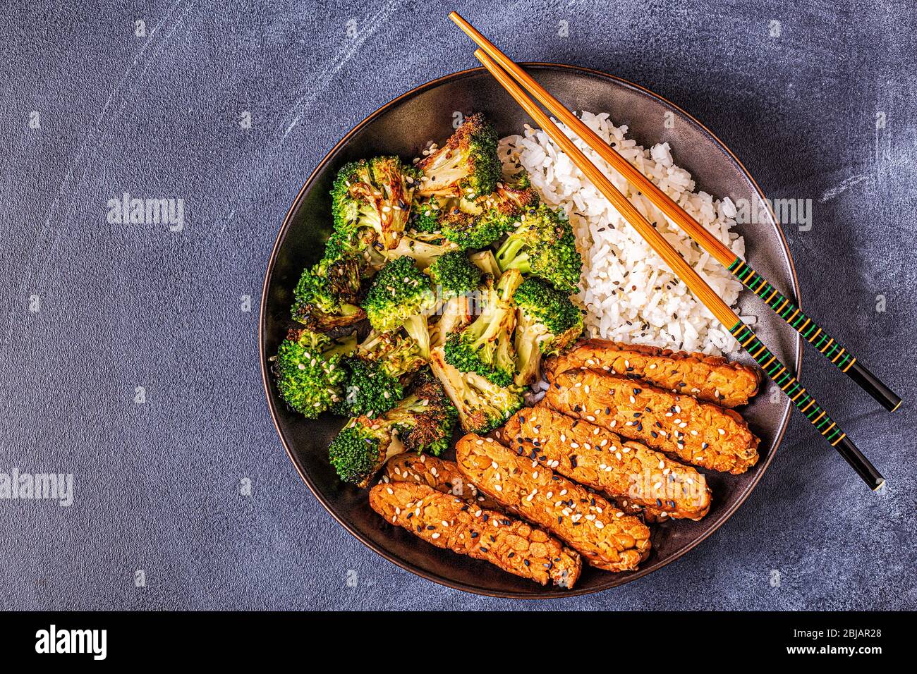 Fried tempeh with rice and broccoli, traditional indonesian cuisine