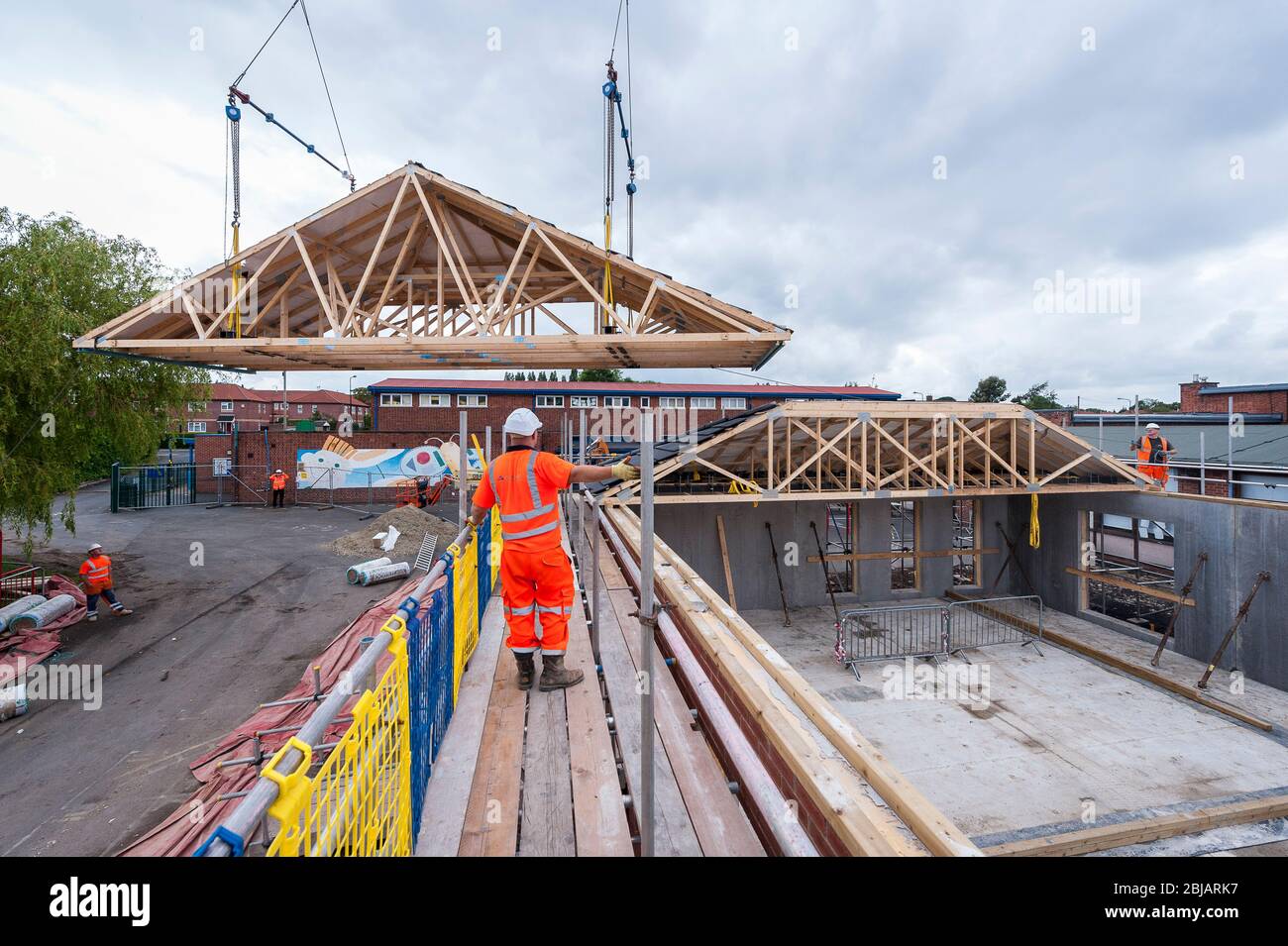 Lowering roof joists onto a building under construction on a building