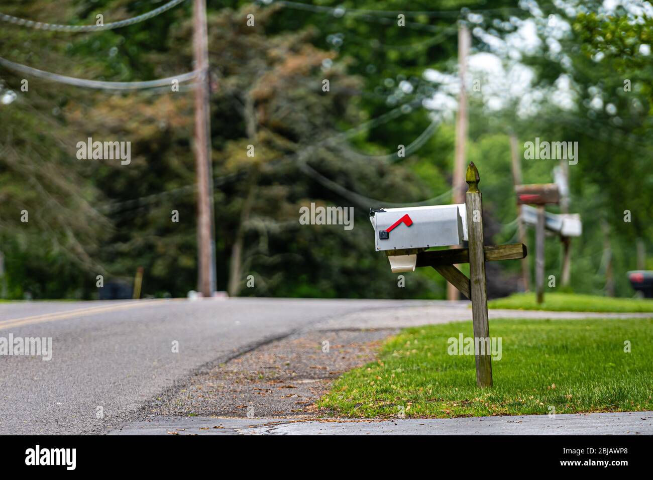 a traditional American mailbox on the side of a village road in