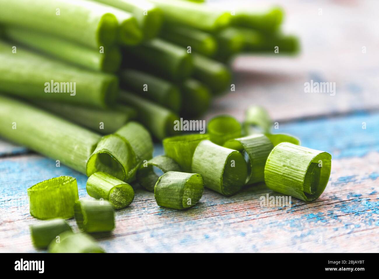 Fresh green onion sliced in rings and lies on the table. Onions are