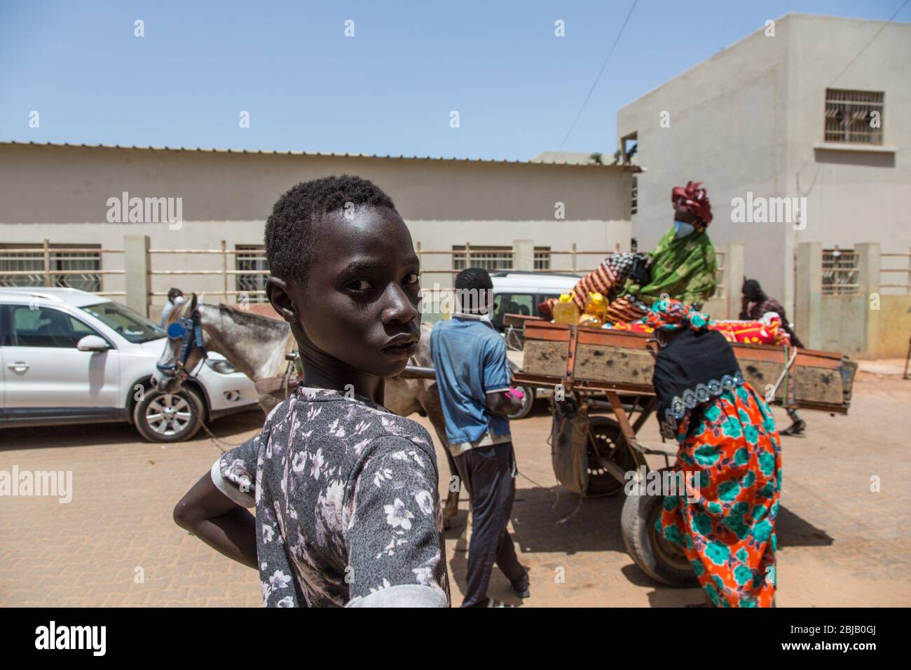 Dakar, Senegal. 28th Apr, 2020. Two women wait for a horse carriage to  carry home the food aid kits they received in Pikine, Senegal, on April 28,  2020. The Senegalese government on