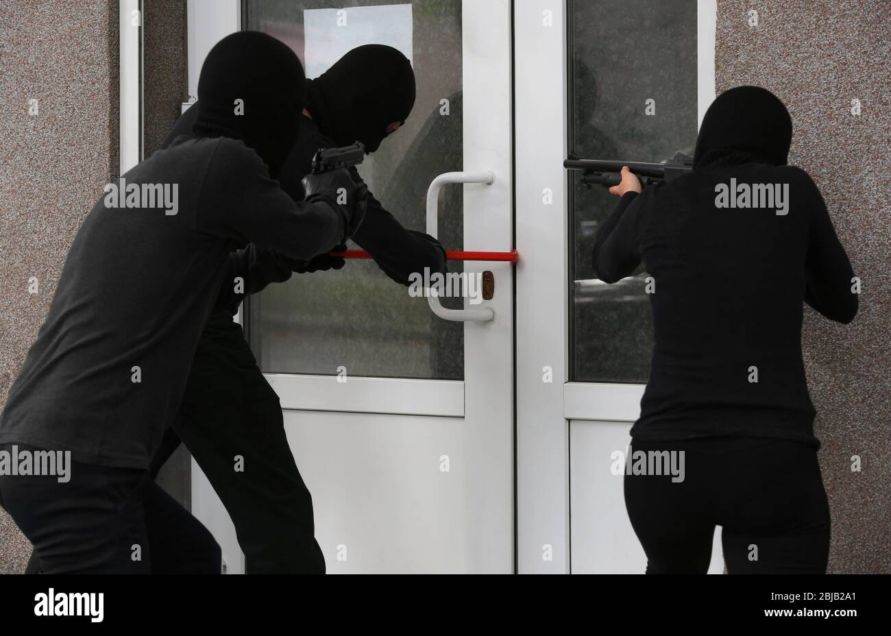 Armed thieves breaking a door Stock Photo