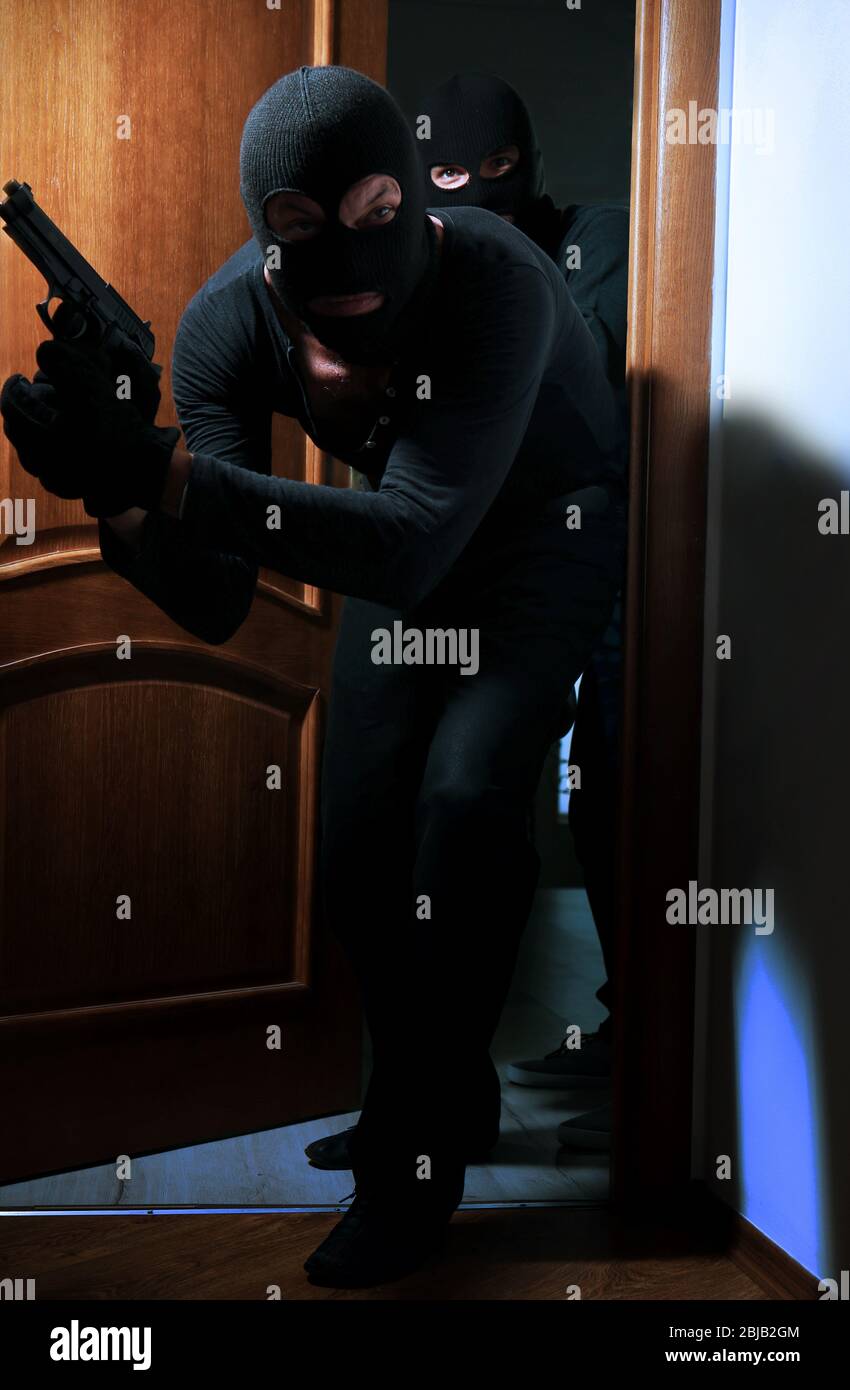 Armed thieves entering a house Stock Photo