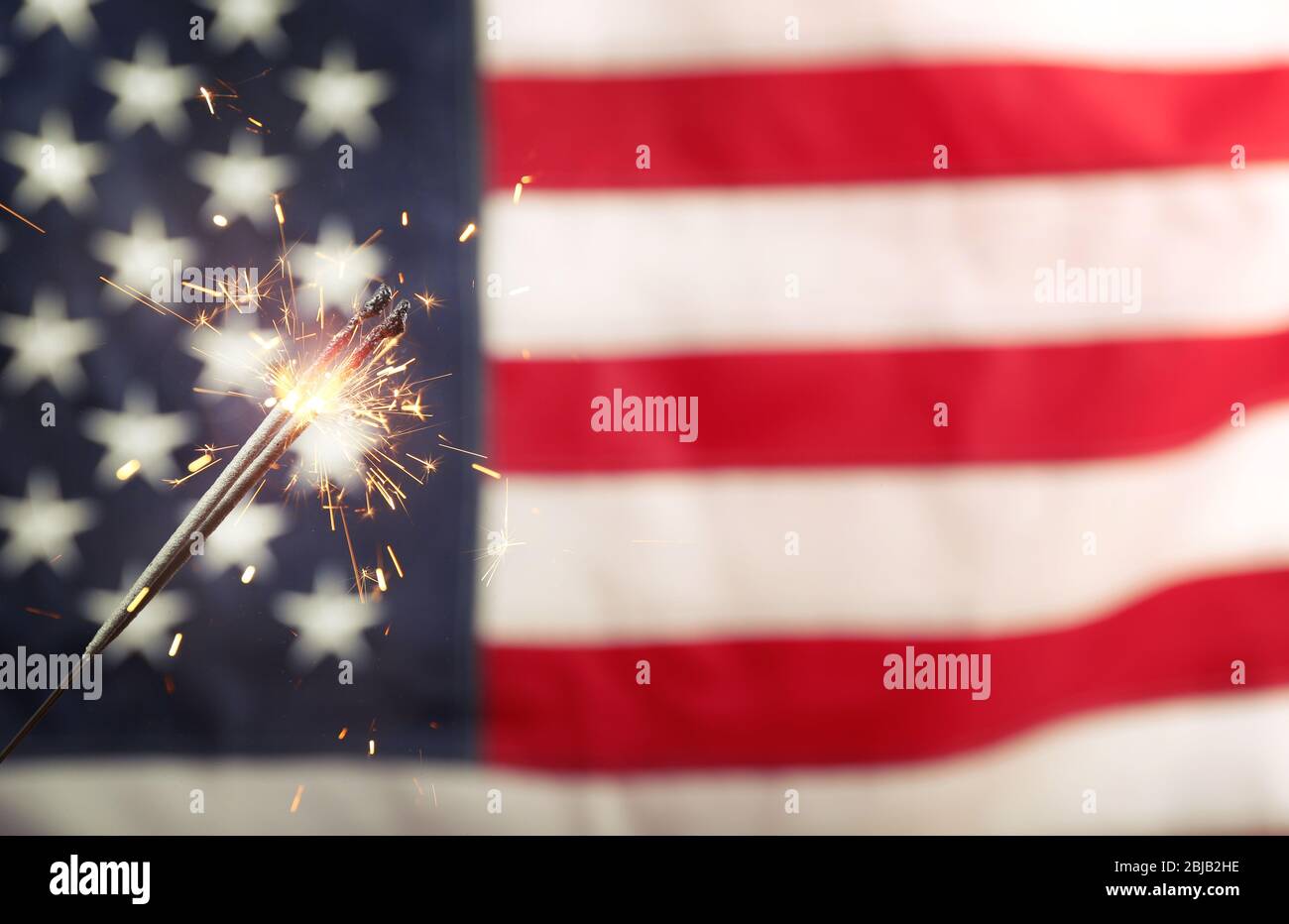 Sparkler on USA flag background Stock Photo - Alamy
