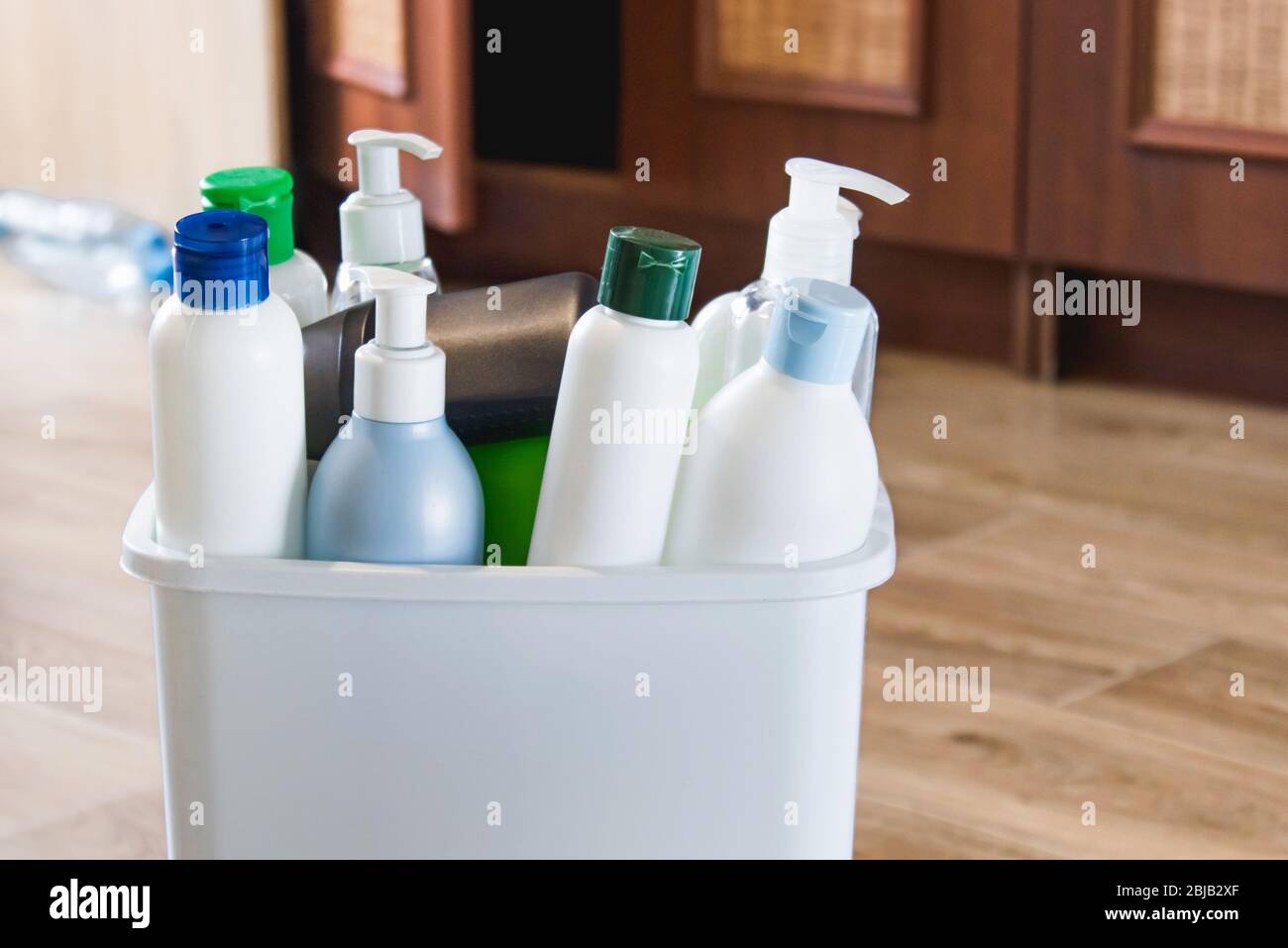 White trash can with household trash. Plastic bottles in the bin. Trash bin with garbage in the kitchen. Stock Photo