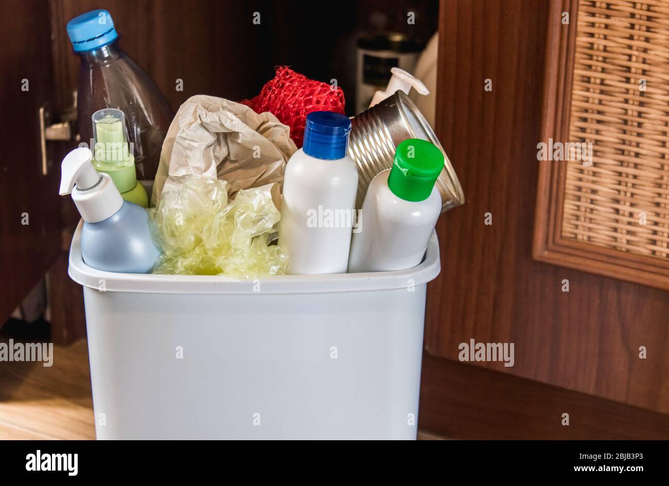 Plastic trash can near the kitchen cabinet - bottles, plastic and metal ...