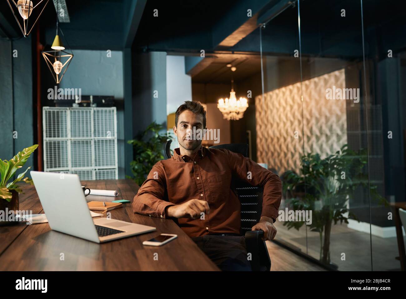Businessman working late at his desk in a dark office Stock Photo