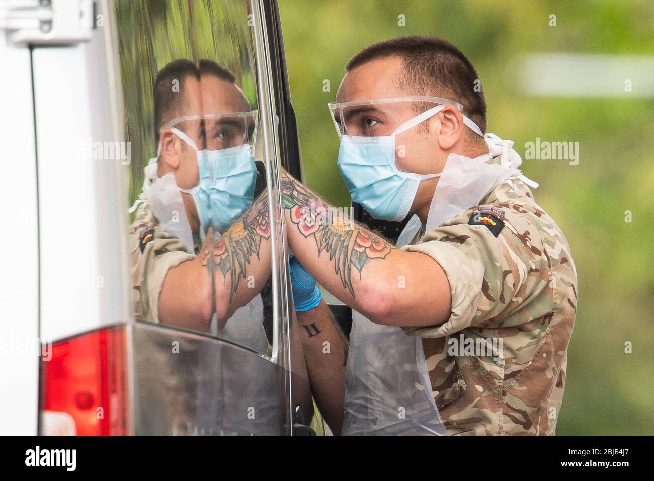 A member of the armed forces working at a drive-in coronavirus testing facility at the Chessington World of Adventures Resort in south west London. Stock Photo