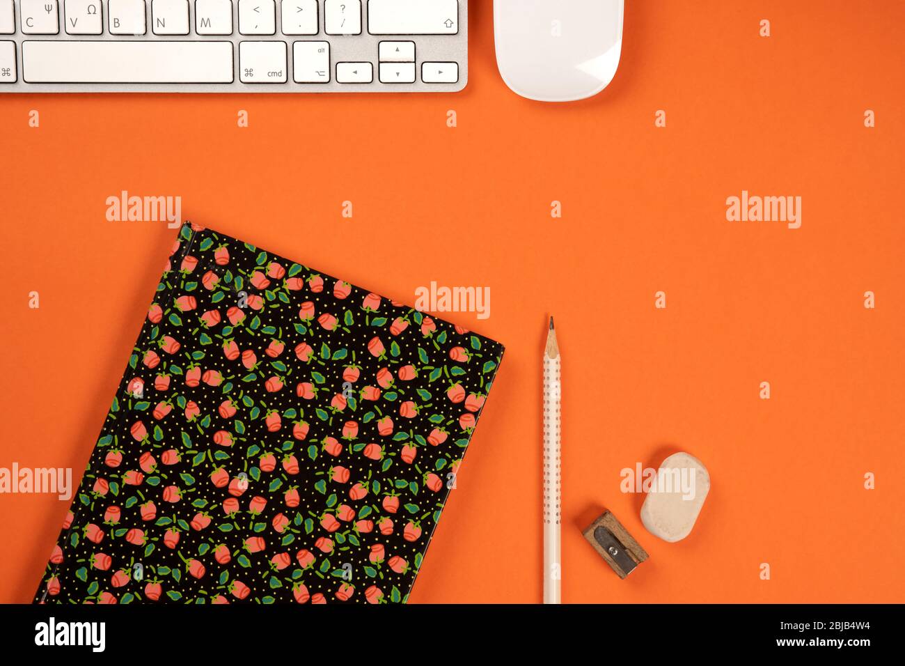 Above orange office desk with, notebook, computer keyboard and mouse. Top view concept Stock Photo