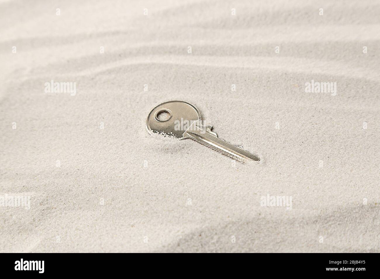 Vintage key on sand Stock Photo - Alamy