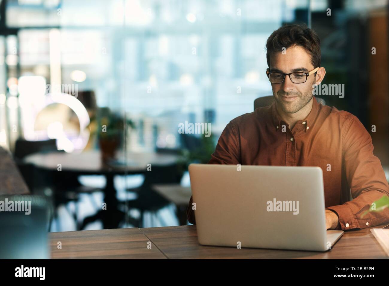Businessman using a laptop while working late in his office Stock Photo