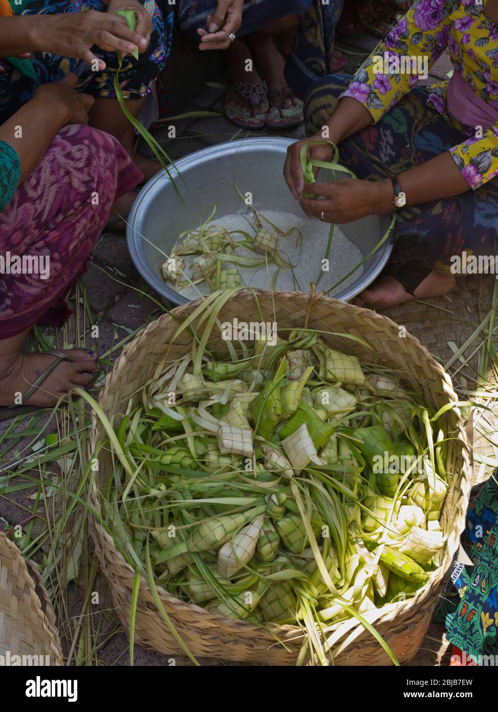 dh Balinese Batuan temple BALI INDONESIA Hindu women making tipat rice packages religion package Ketupat Stock Photo
