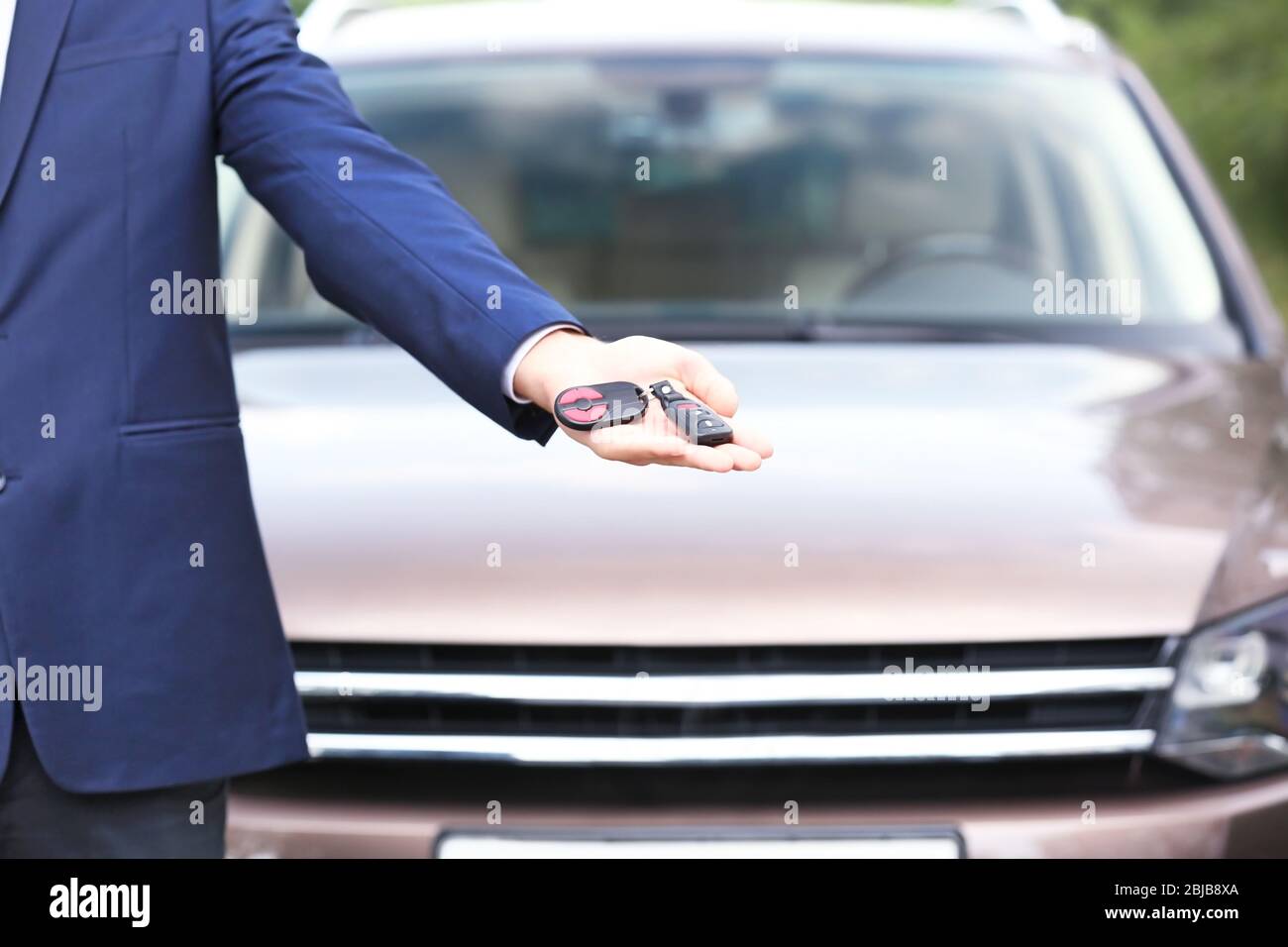 Man using car alarm key on car blurred background Stock Photo - Alamy