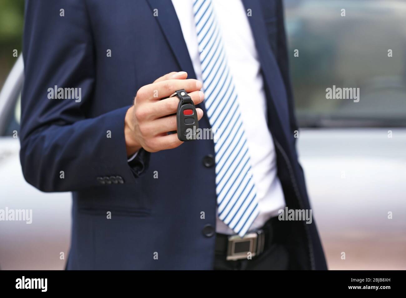 Man using car alarm key on car blurred background Stock Photo - Alamy
