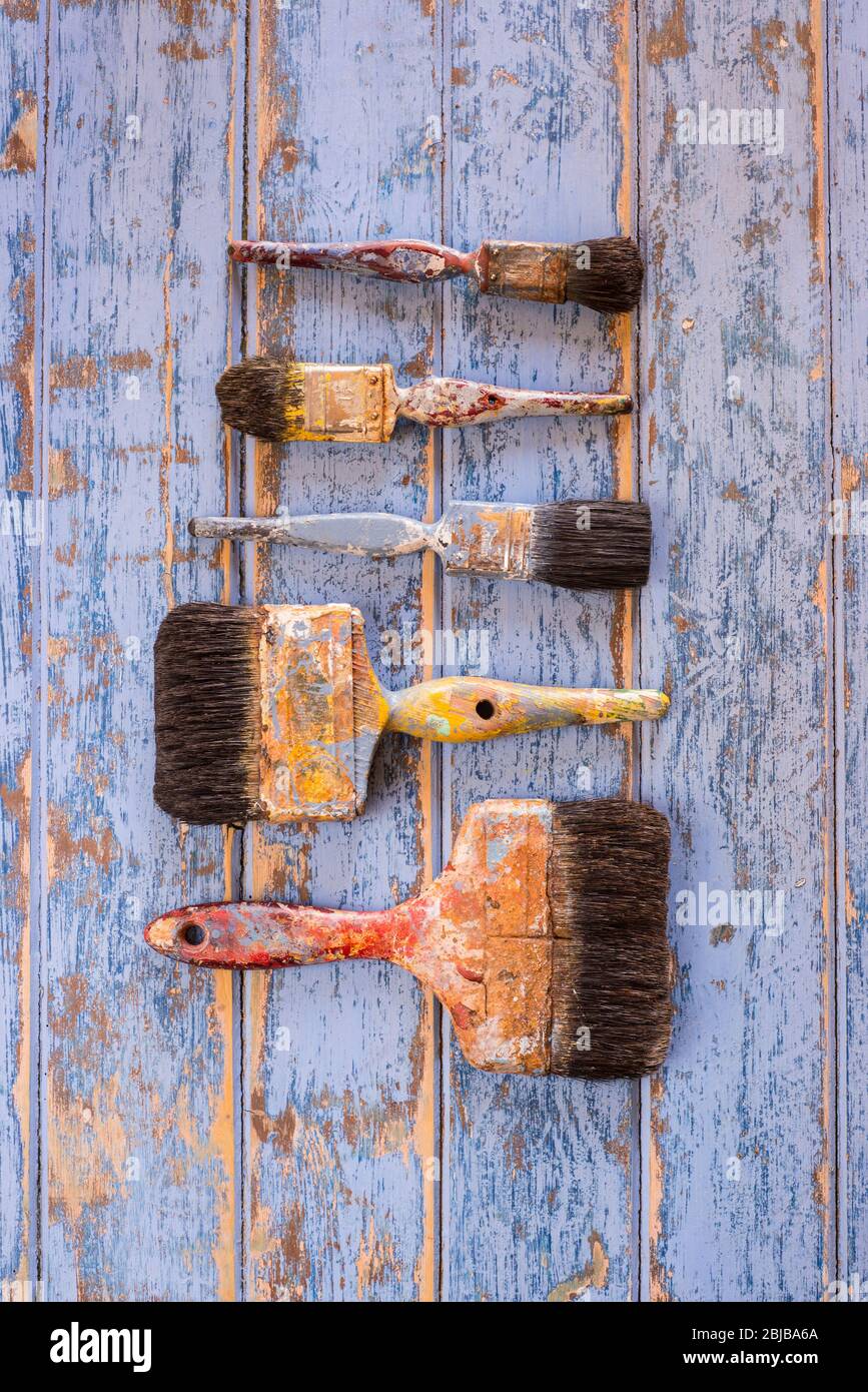 Old well used paintbrushes on a wooden surface. Stock Photo