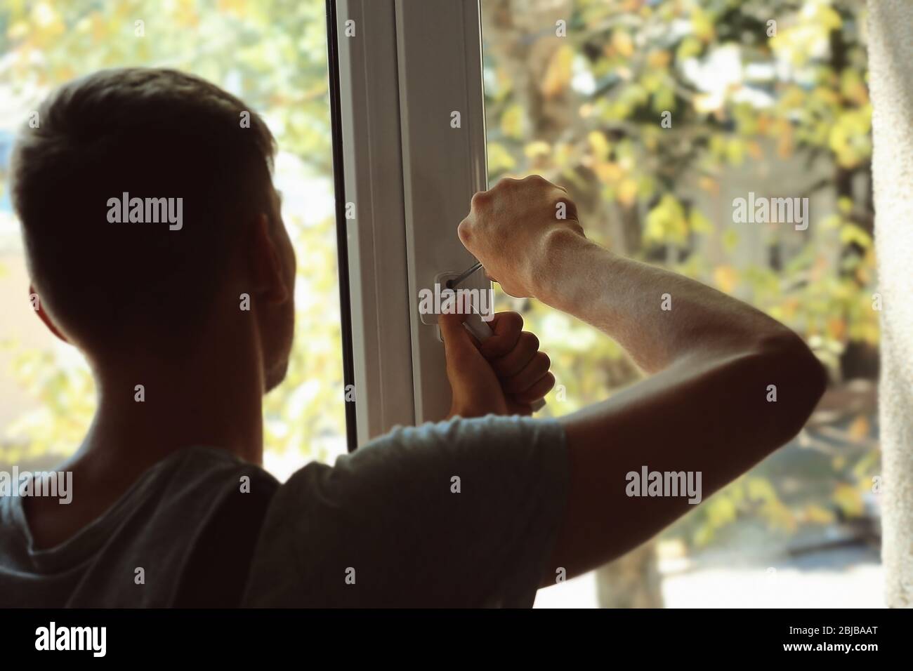Construction worker repairing window handle Stock Photo