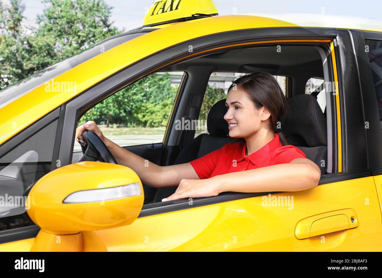 Beautiful female taxi driver sitting in car Stock Photo - Alamy