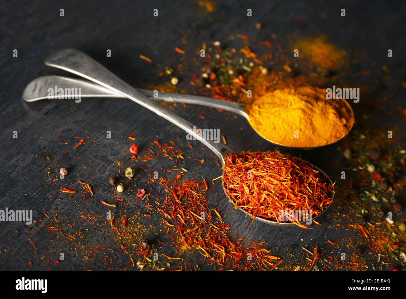 Spices in metal spoons on table Stock Photo