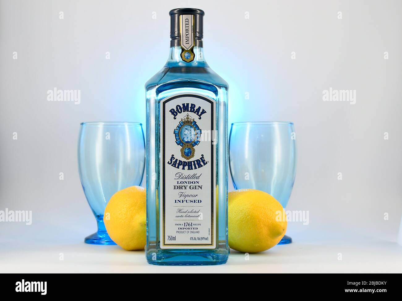 Bottle of Bombay Sapphire gin with two goblets and lemons white background Stock Photo