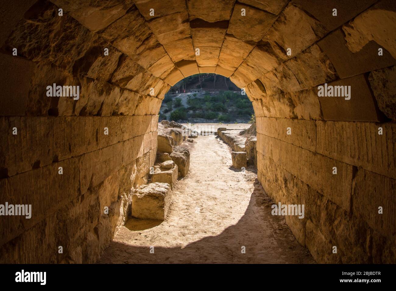 Entrance tunnel from where the athletes entered to the ancient Panhellenic stadium at archaeological site of Nemea in Greece Stock Photo