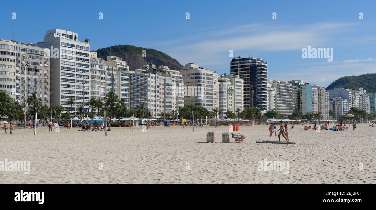Actives and sun bathing on Copacabana Beach, Rio De Janeiro, Brazil with hotel sin the background. Stock Photo