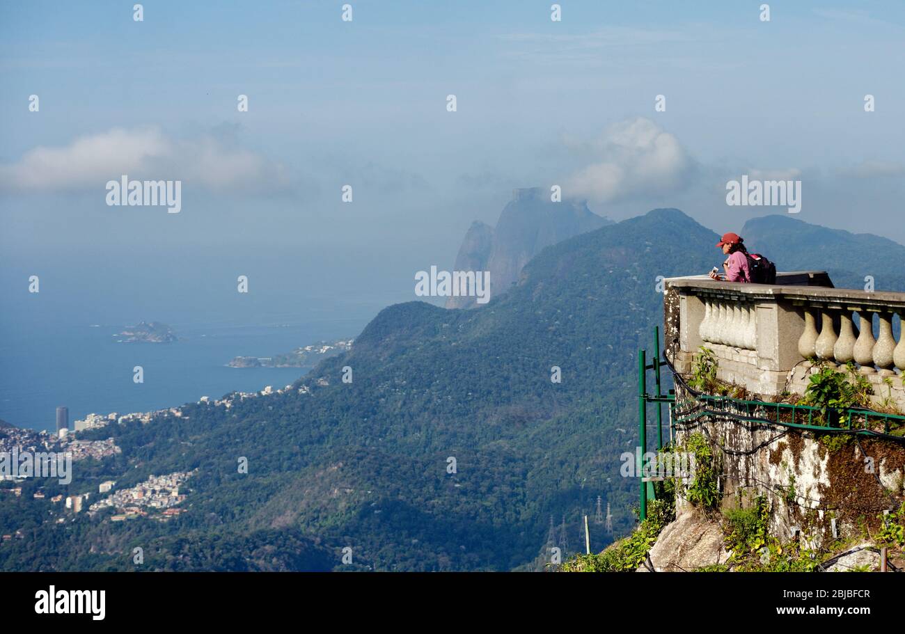 Tourists on the viewing areas of Christ the Redeemer state on Corcovado mountain, looking across Rio De Janeiro, Brazil Stock Photo