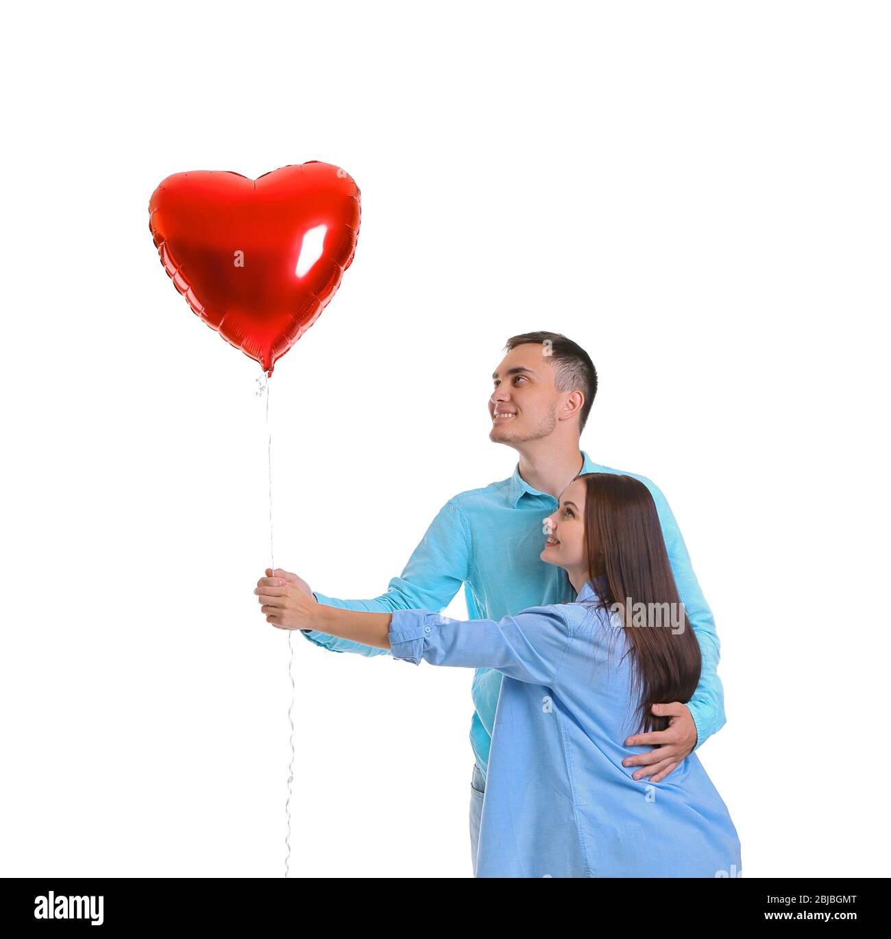 Happy couple with red balloon on white background Stock Photo - Alamy