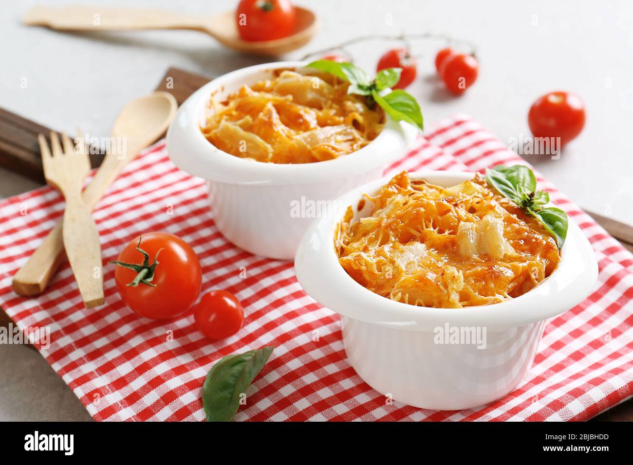 Portions of pasta Al Forno in ceramic bowls on red napkin, closeup Stock Photo