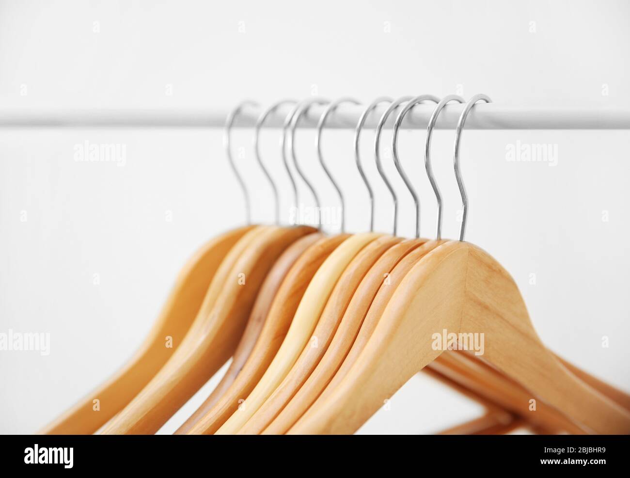 https://c8.alamy.com/comp/2BJBHR9/wooden-coat-hangers-on-clothes-rail-and-white-background-2BJBHR9.jpg